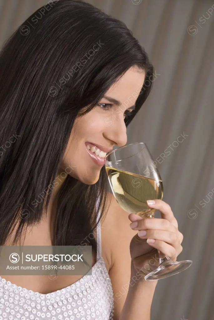 Hispanic woman drinking wine