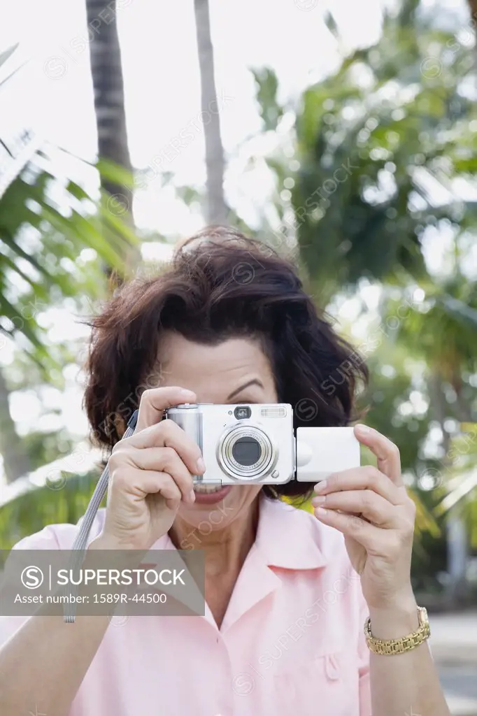 Hispanic woman taking photograph