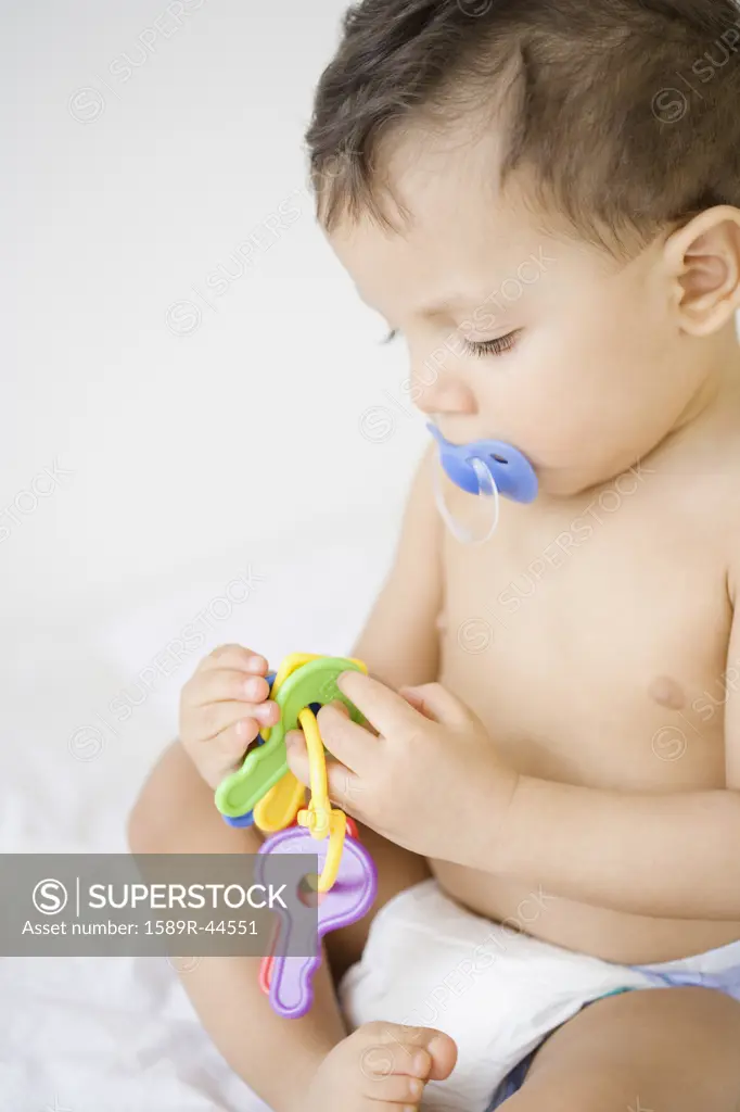 Hispanic baby playing with toy keys