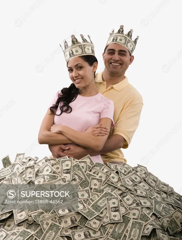 Hispanic couple standing in pile of money