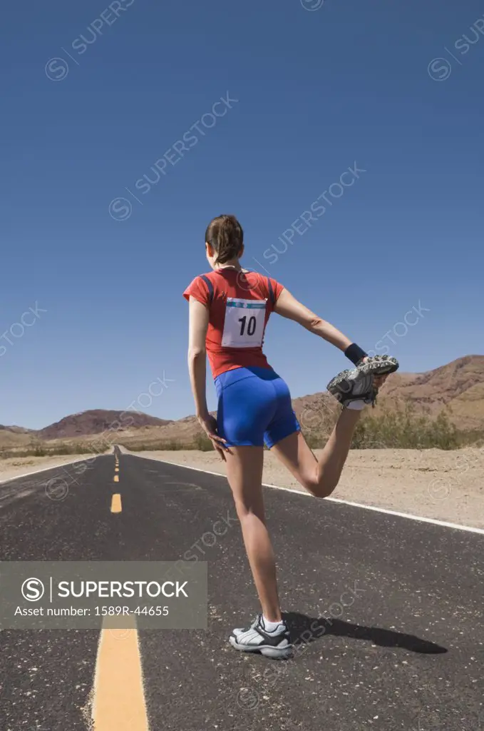 Mixed Race female runner stretching