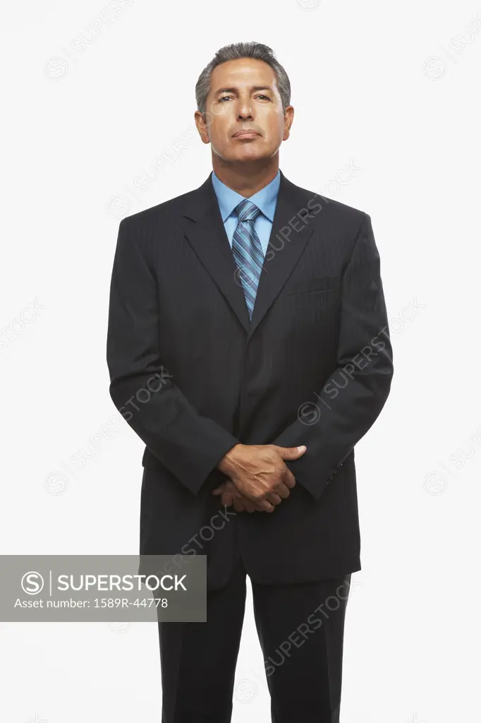 Hispanic businessman with hands clasped