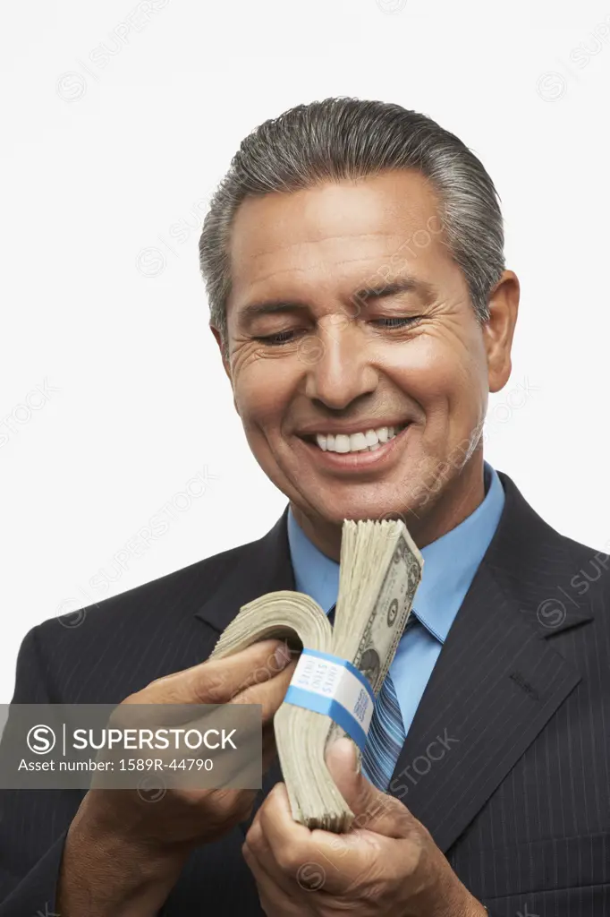 Hispanic businessman holding stack of money
