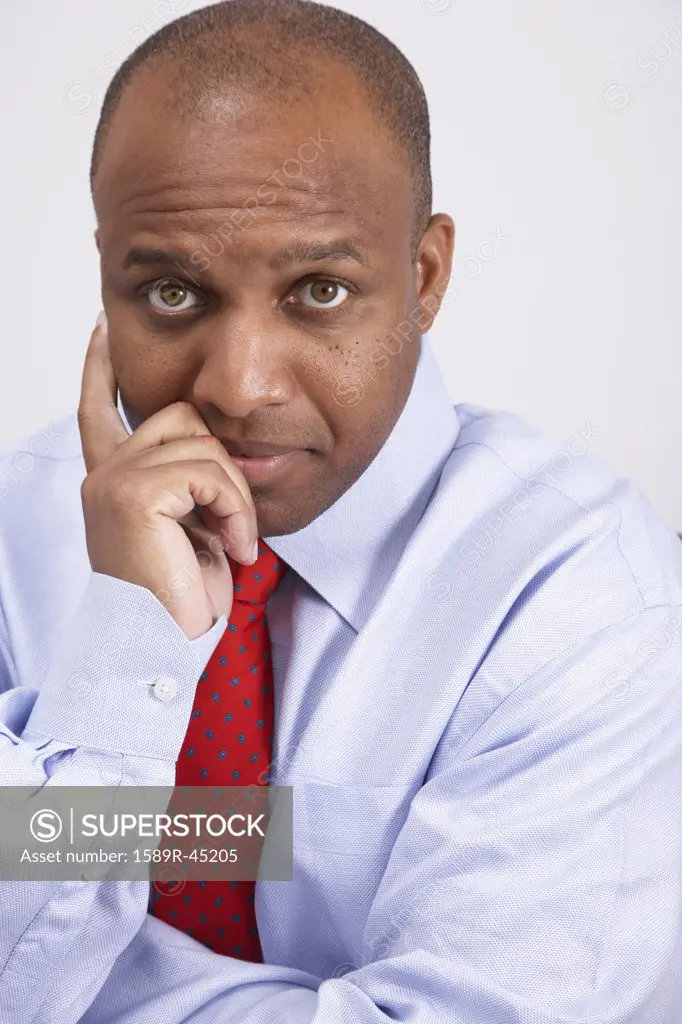African American businessman leaning chin on hand