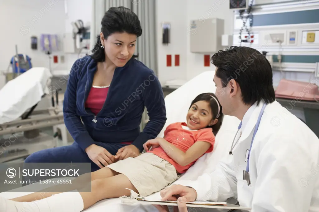 Hispanic mother and daughter talking to doctor