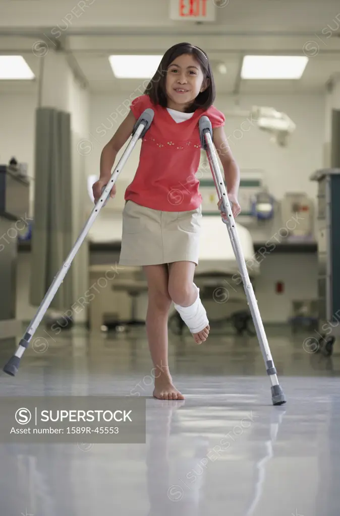 Hispanic girl walking with crutches