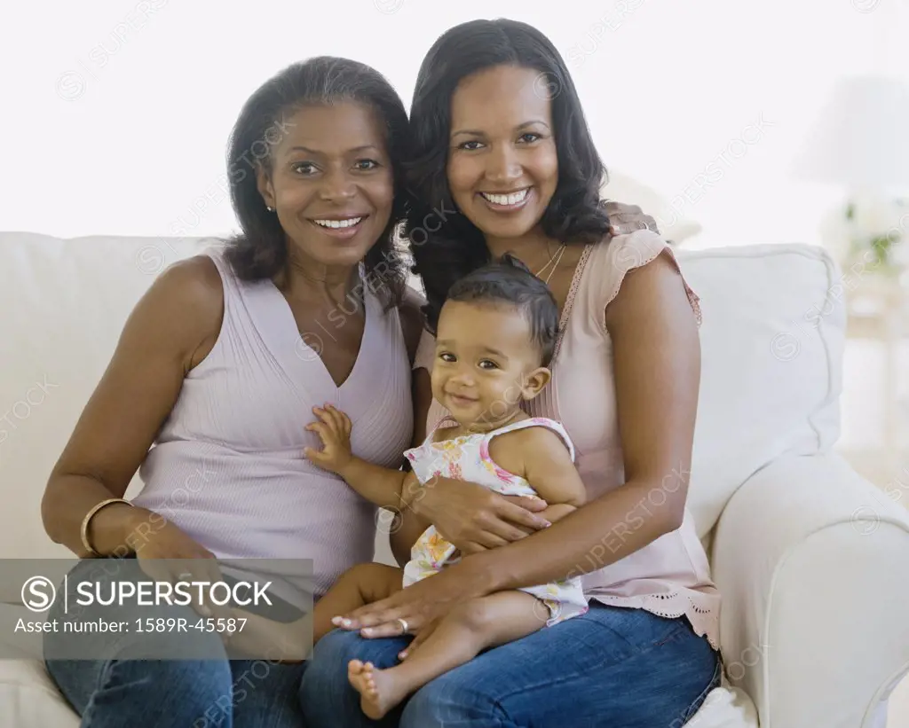 African American grandmother, mother and baby on sofa