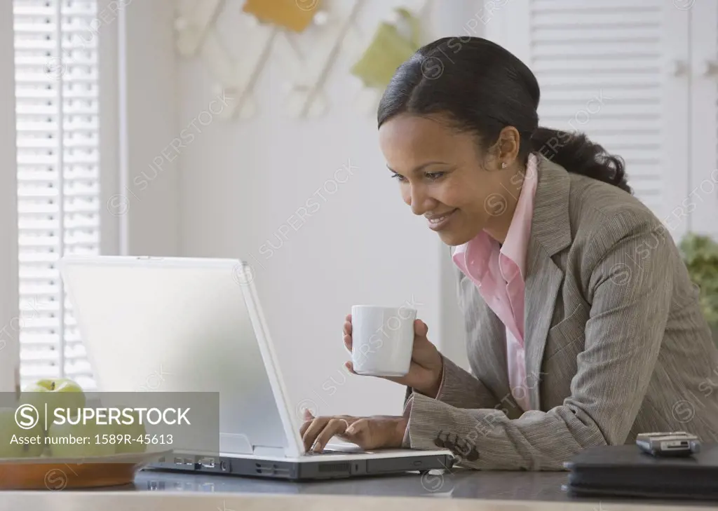 African American businesswoman looking at laptop