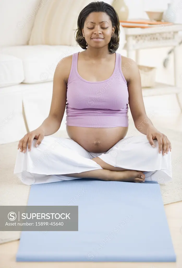 Pregnant African American woman practicing yoga