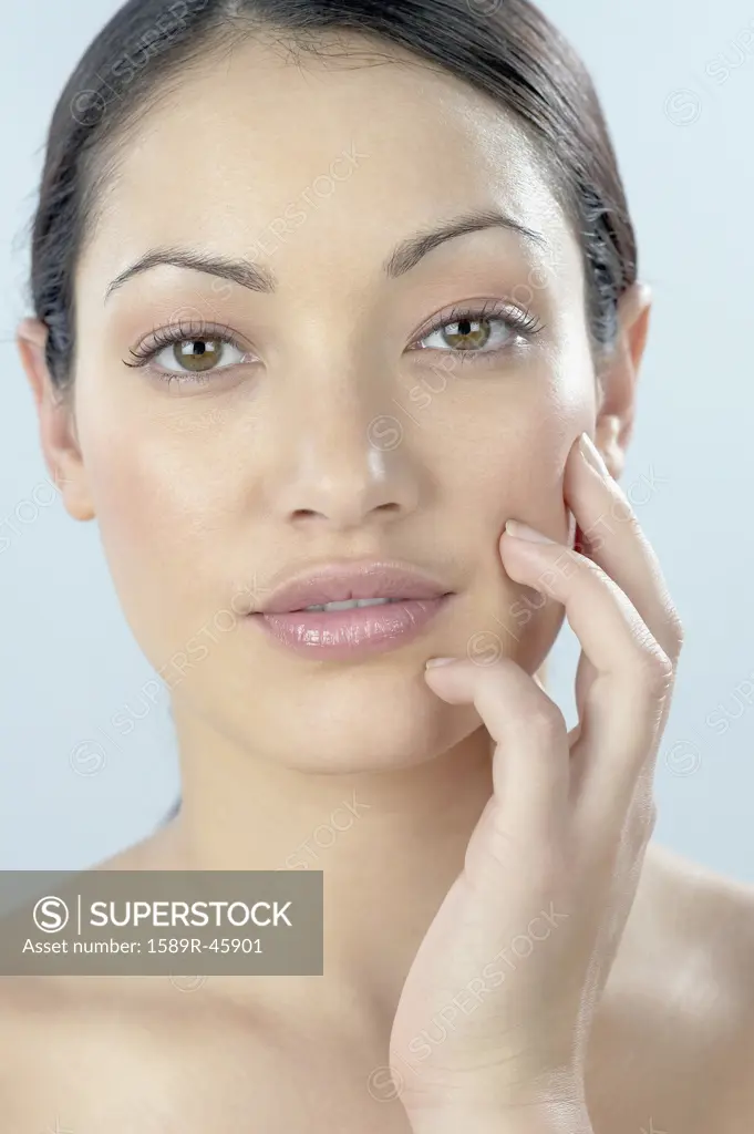 Mixed Race woman with hand on face