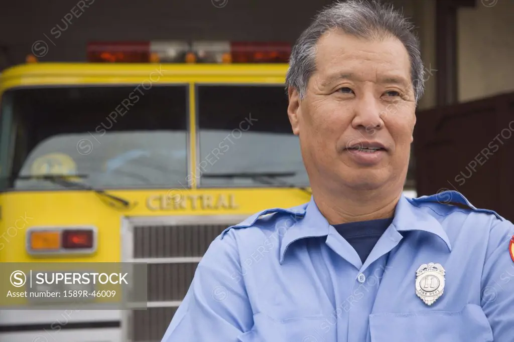Asian male paramedic in front of ambulance