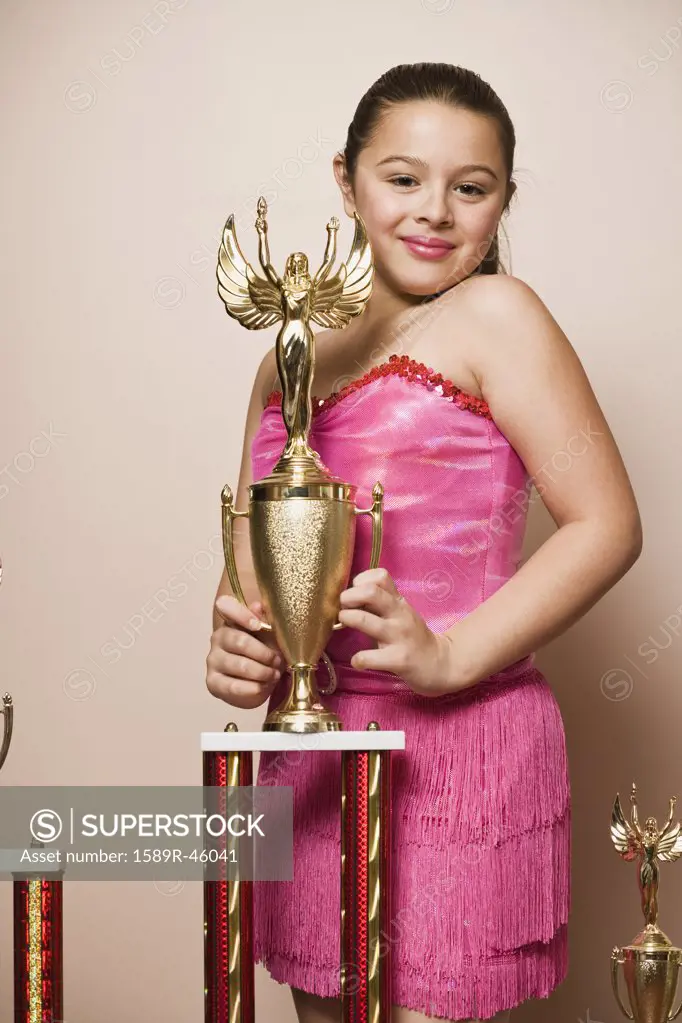 Mixed Race girl holding dancing trophy