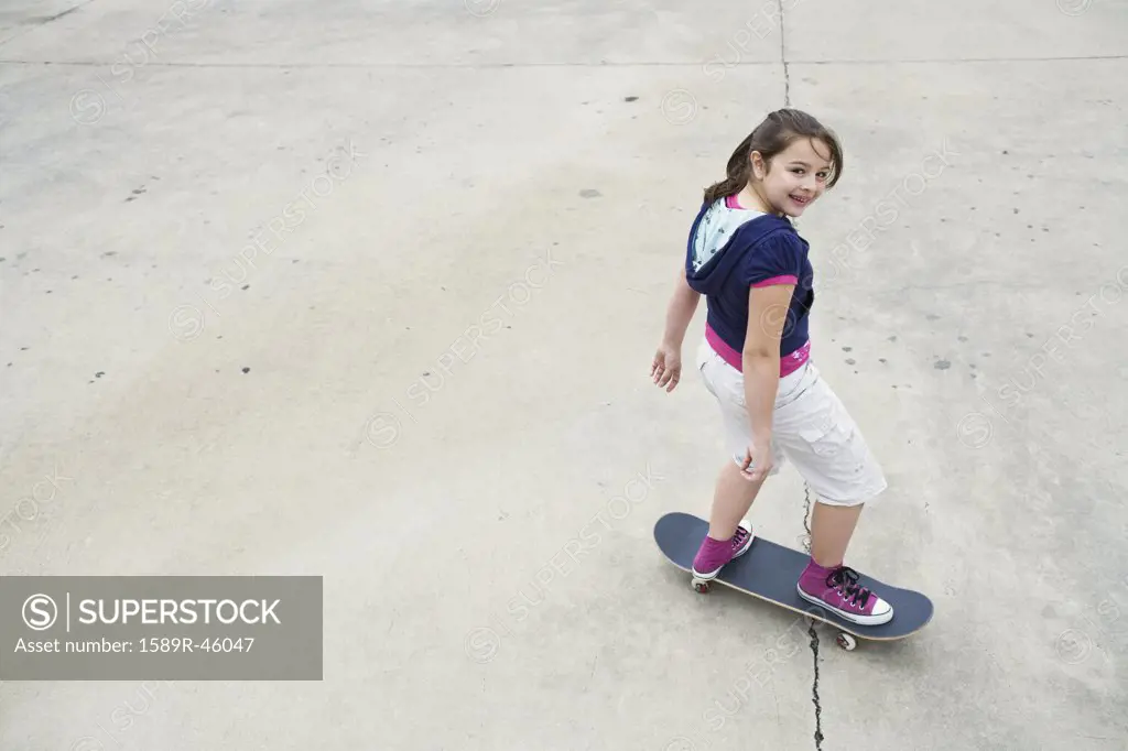 Mixed Race girl riding skateboard