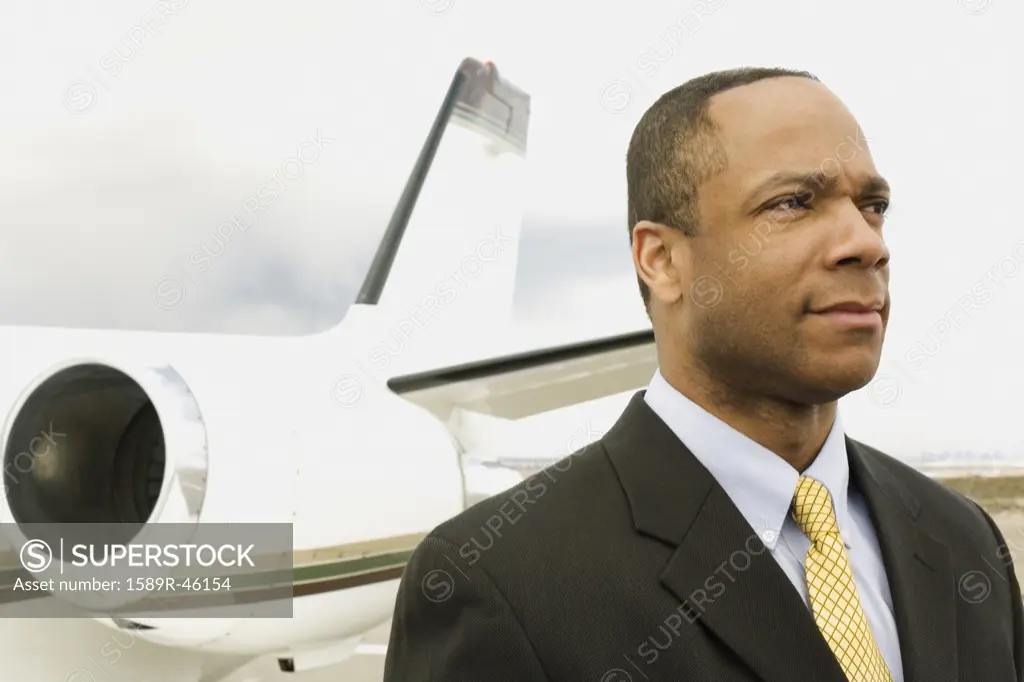 African businessman next to airplane