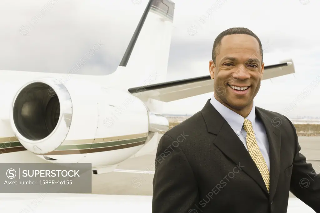 African businessman next to airplane