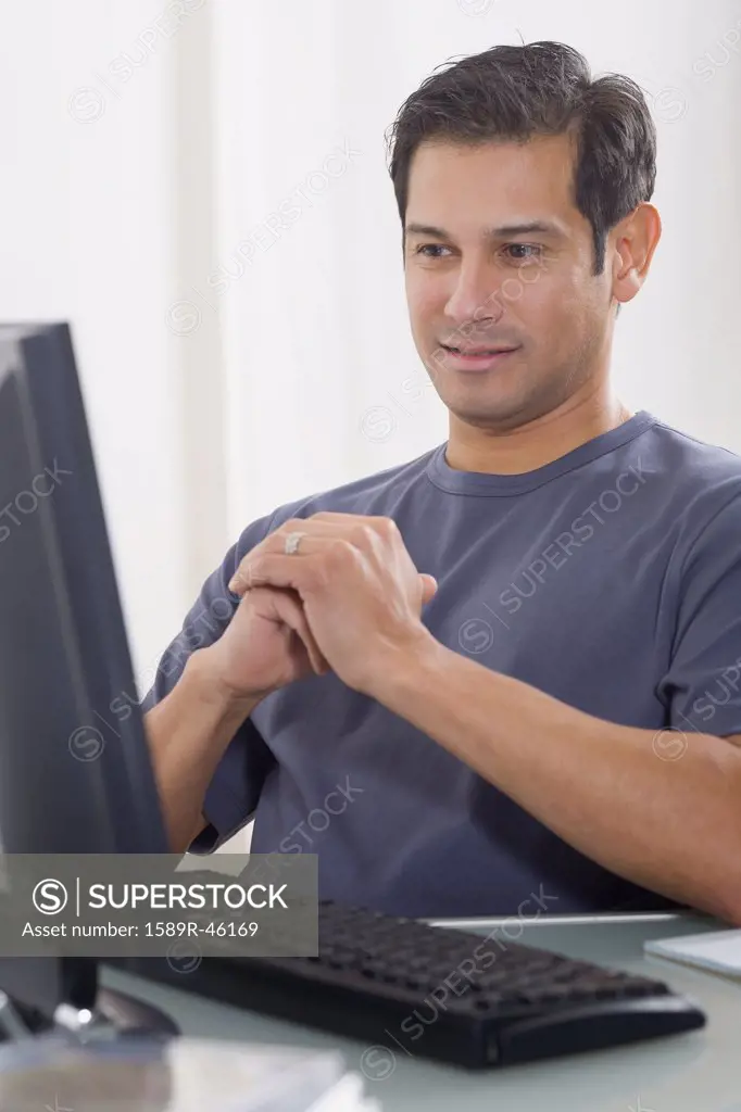 Hispanic man looking at computer