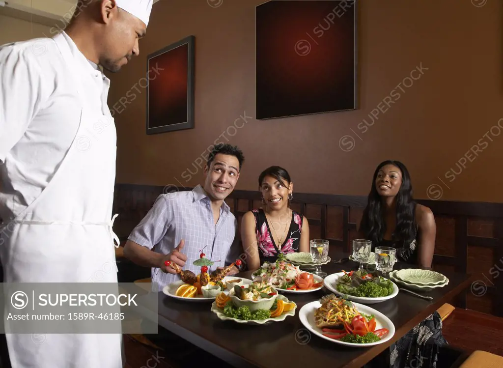 Multi-ethnic friends complimenting chef