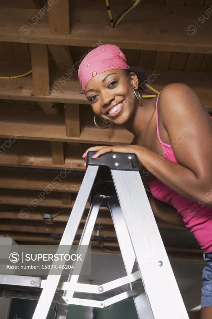 African woman standing on ladder