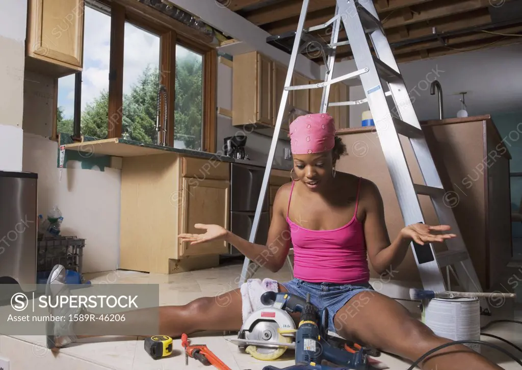 African woman shrugging shoulders at power tools