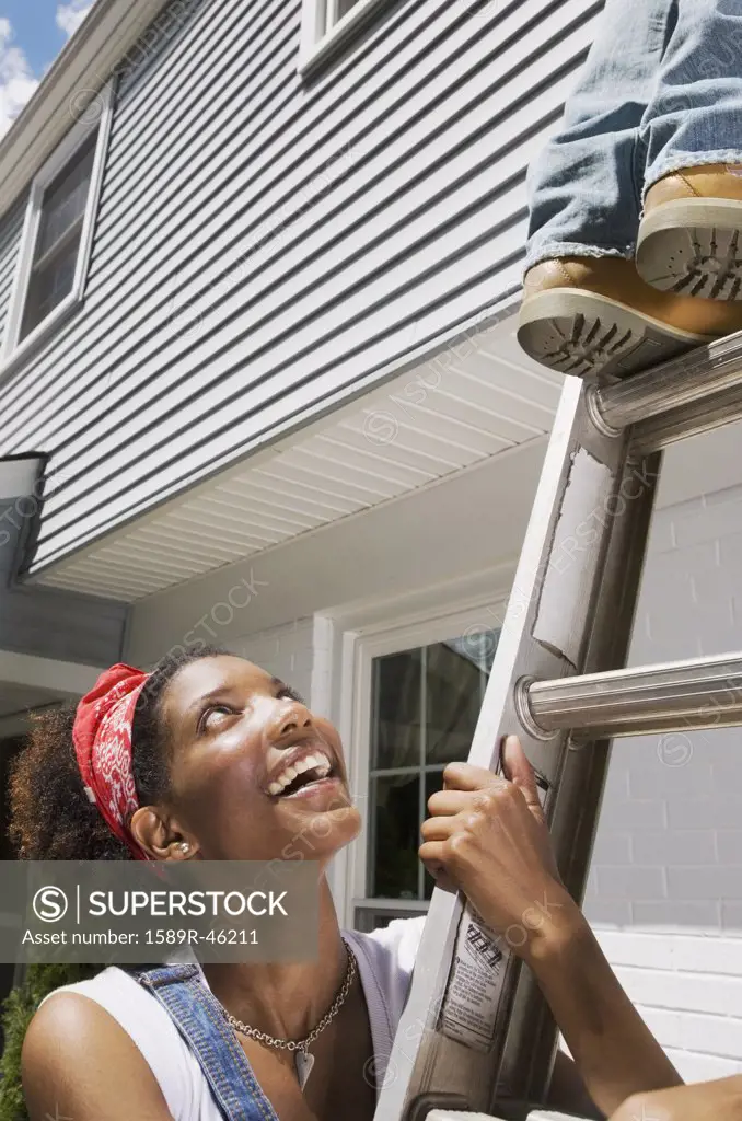 African American woman holding ladder