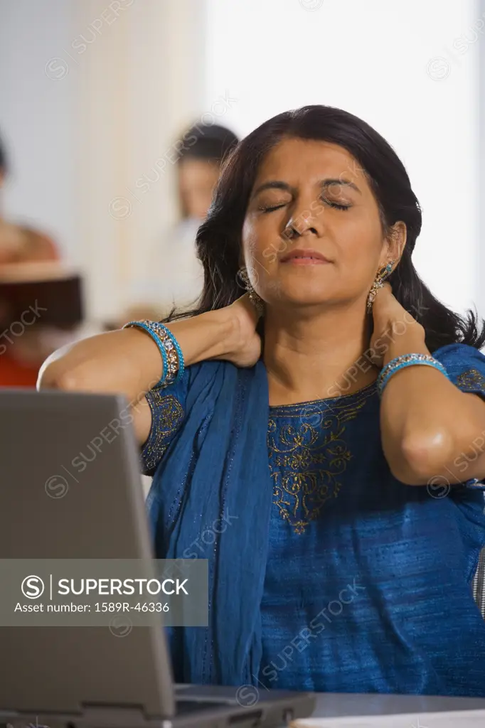 Indian businesswoman rubbing neck