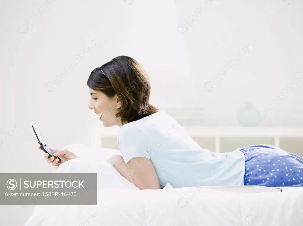 Mixed Race woman looking at cell phone