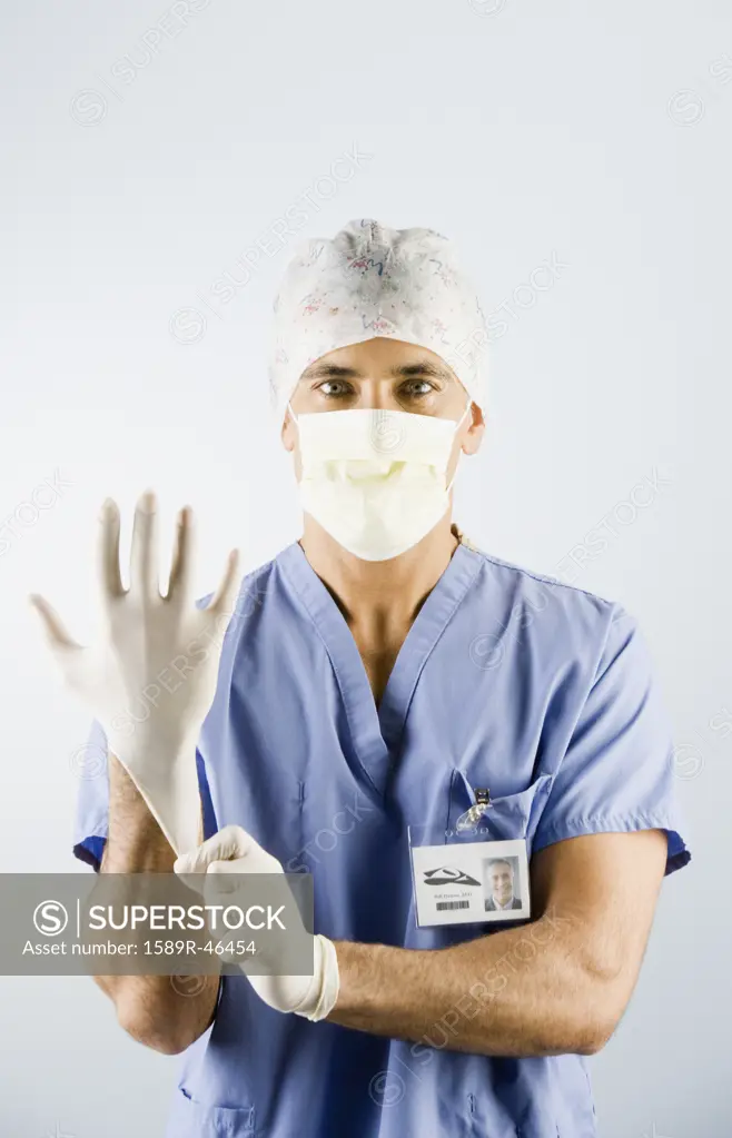 Middle Eastern male doctor putting on gloves