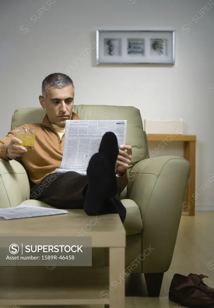 Middle Eastern man reading newspaper