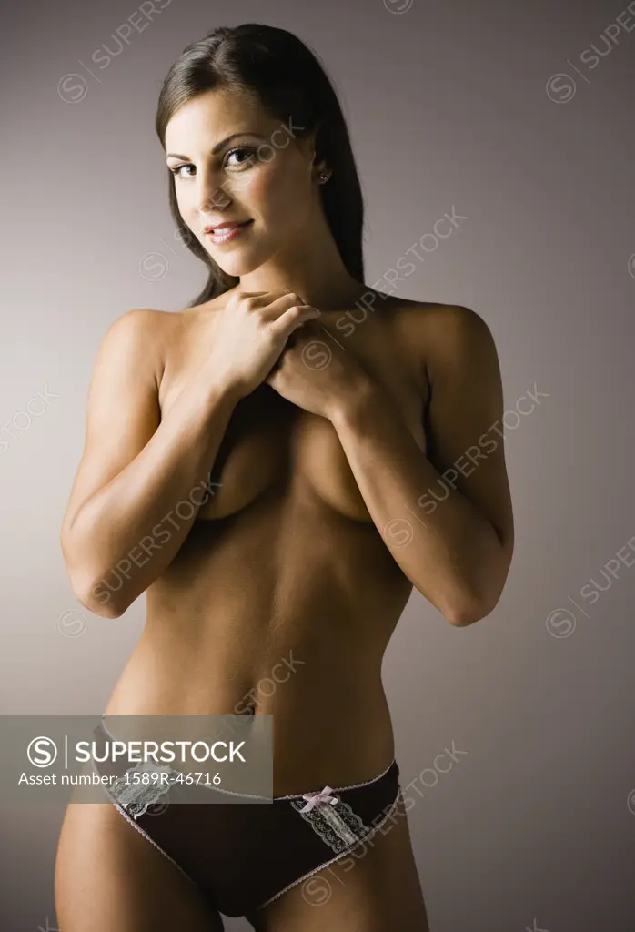 Semi-nude woman covering breasts