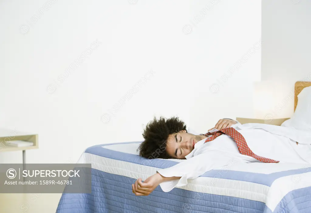 Mixed Race man sleeping on bed
