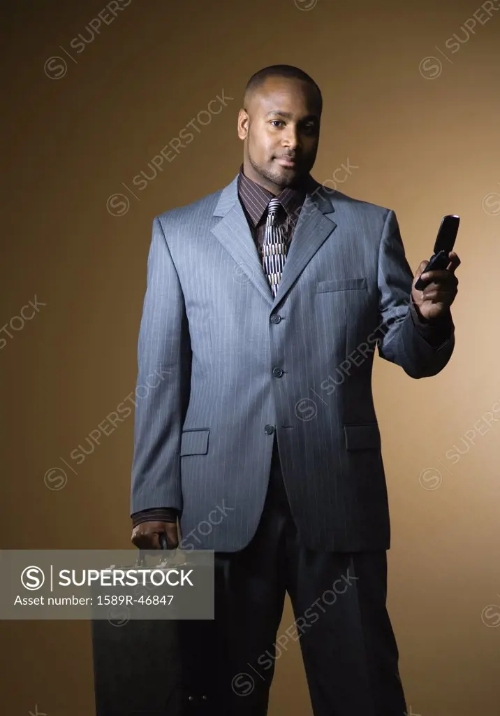 African American businessman holding cell phone