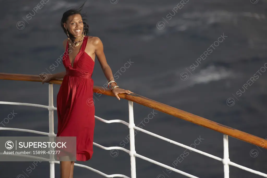 Hispanic woman leaning on ship railing