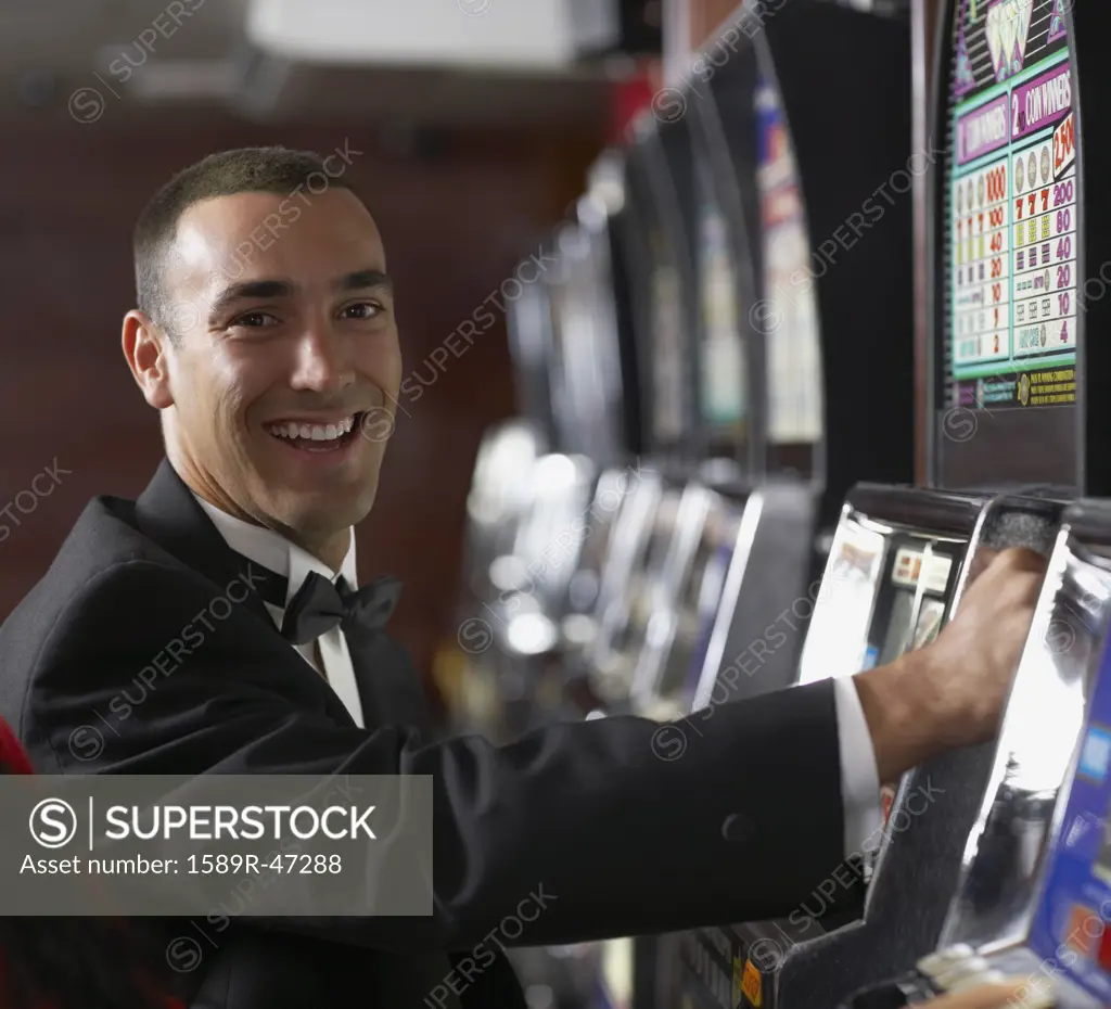 Hispanic man at slot machine
