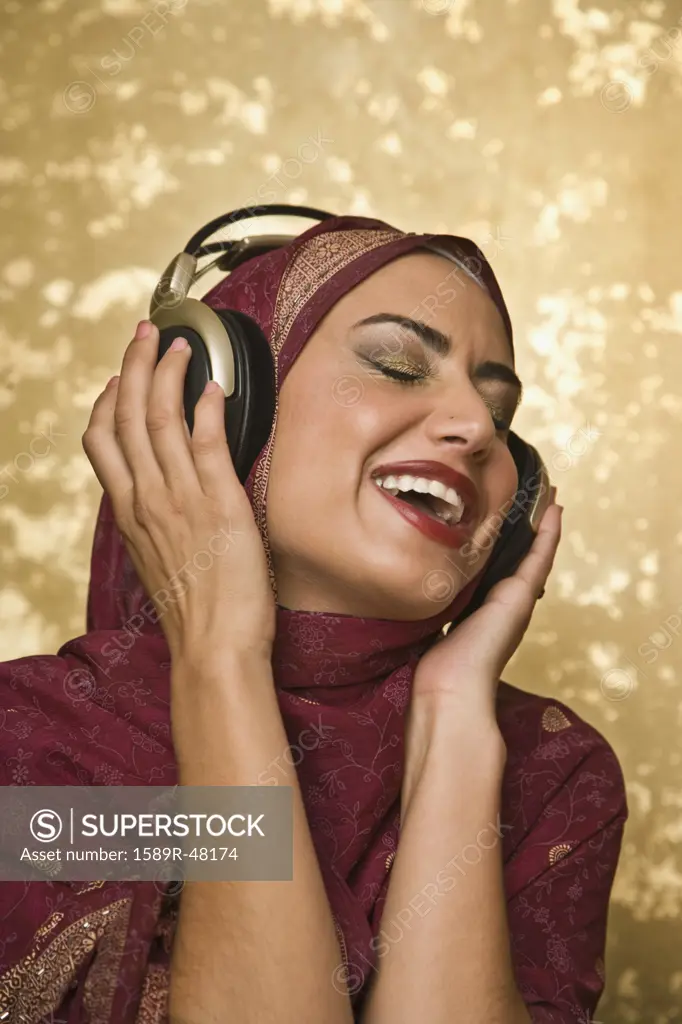Middle Eastern woman listening to headphones