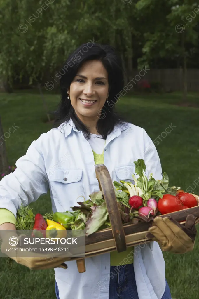 Hispanic woman holding fresh vegetables