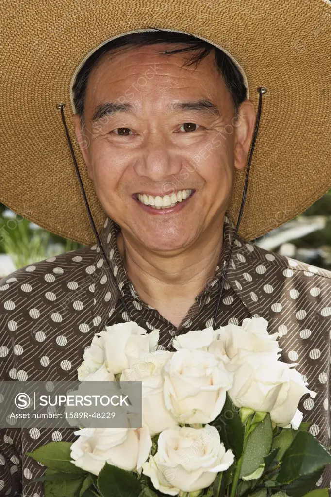 Senior Asian man holding flowers