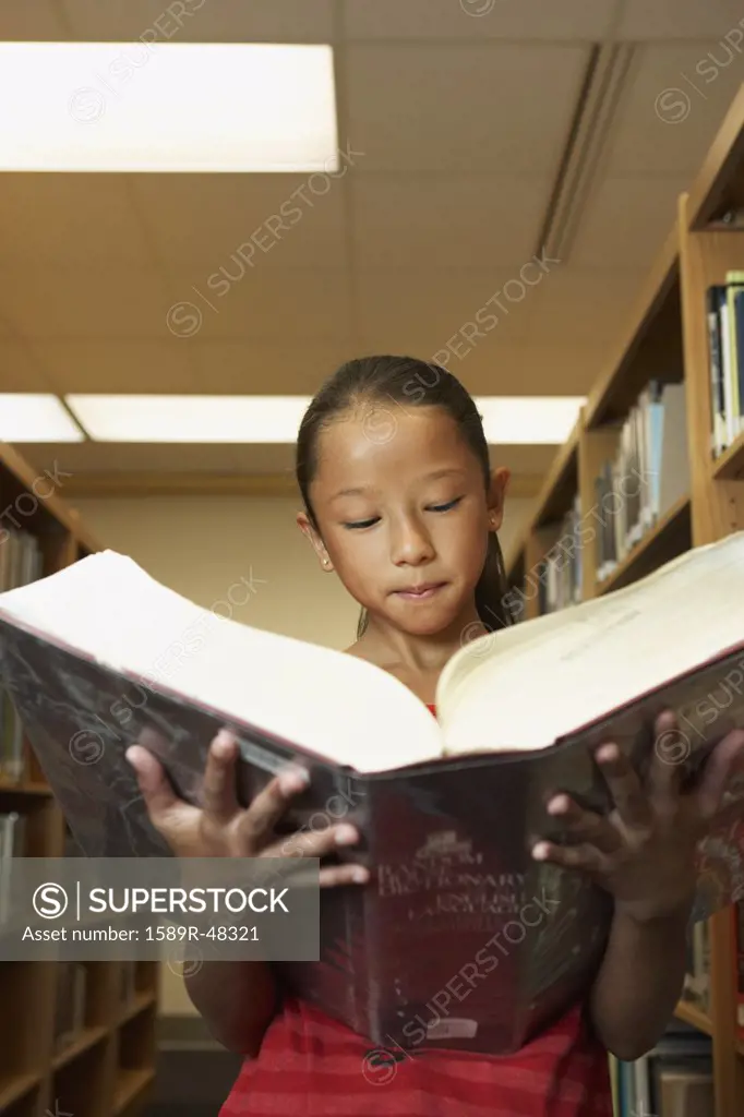 Asian girl reading library dictionary