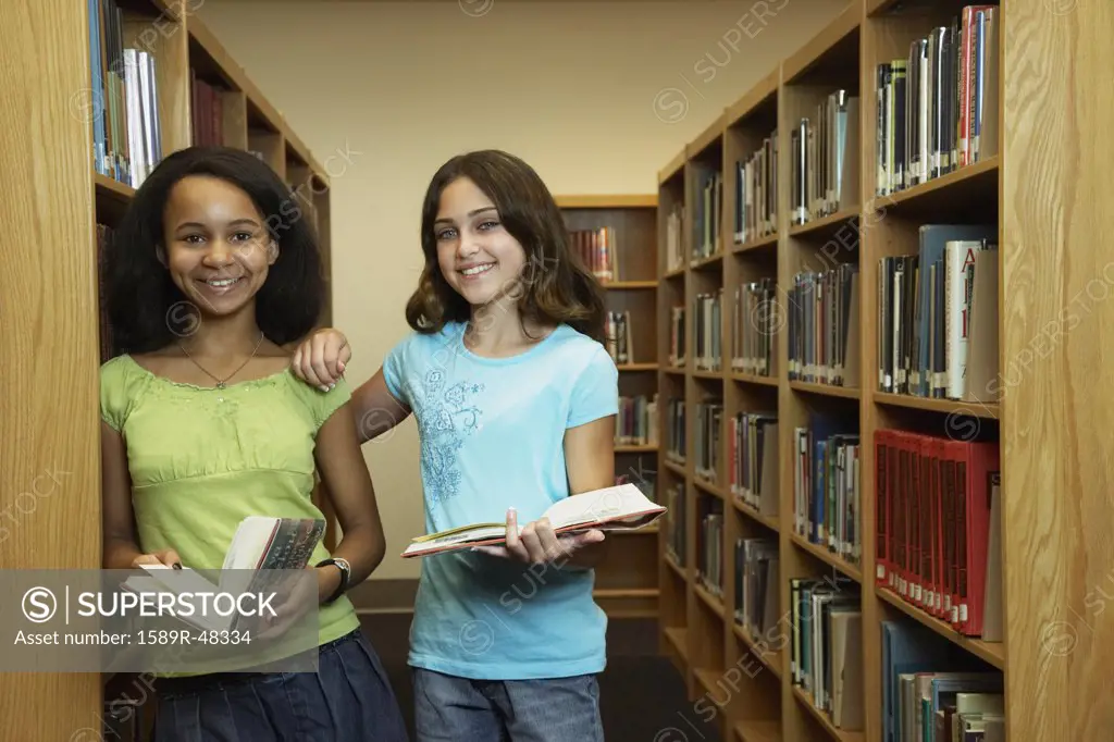 Multi-ethnic girls holding library books