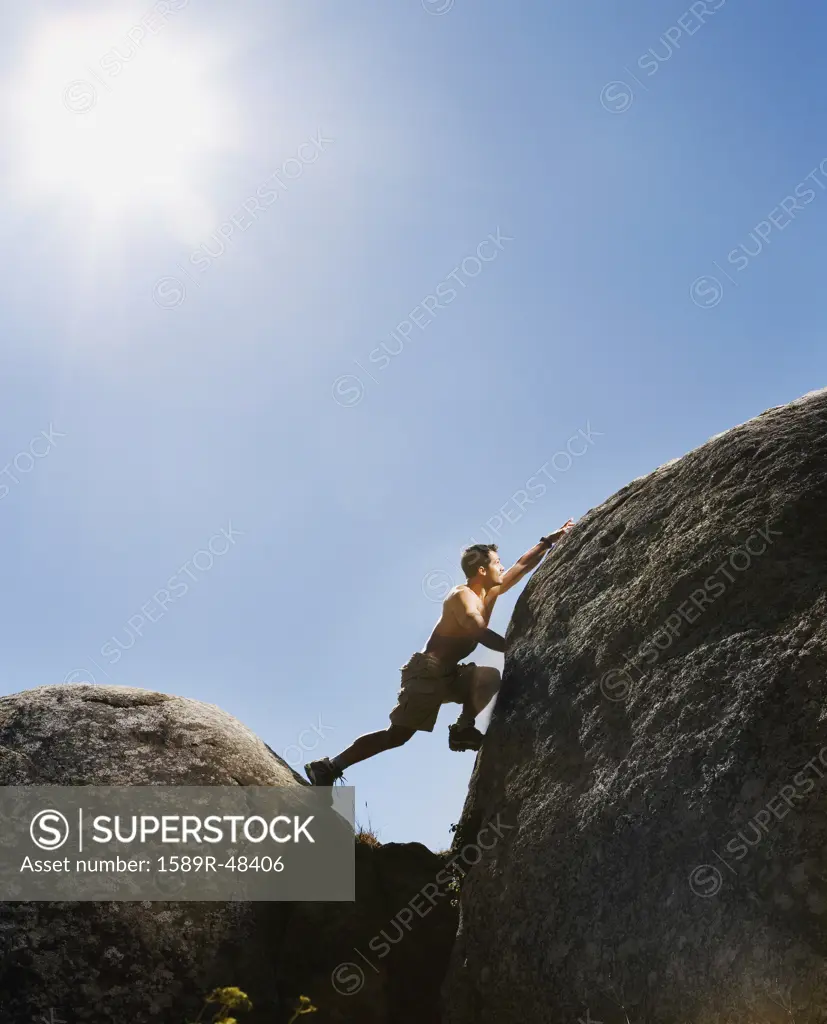Pacific Islander man climbing rock formations