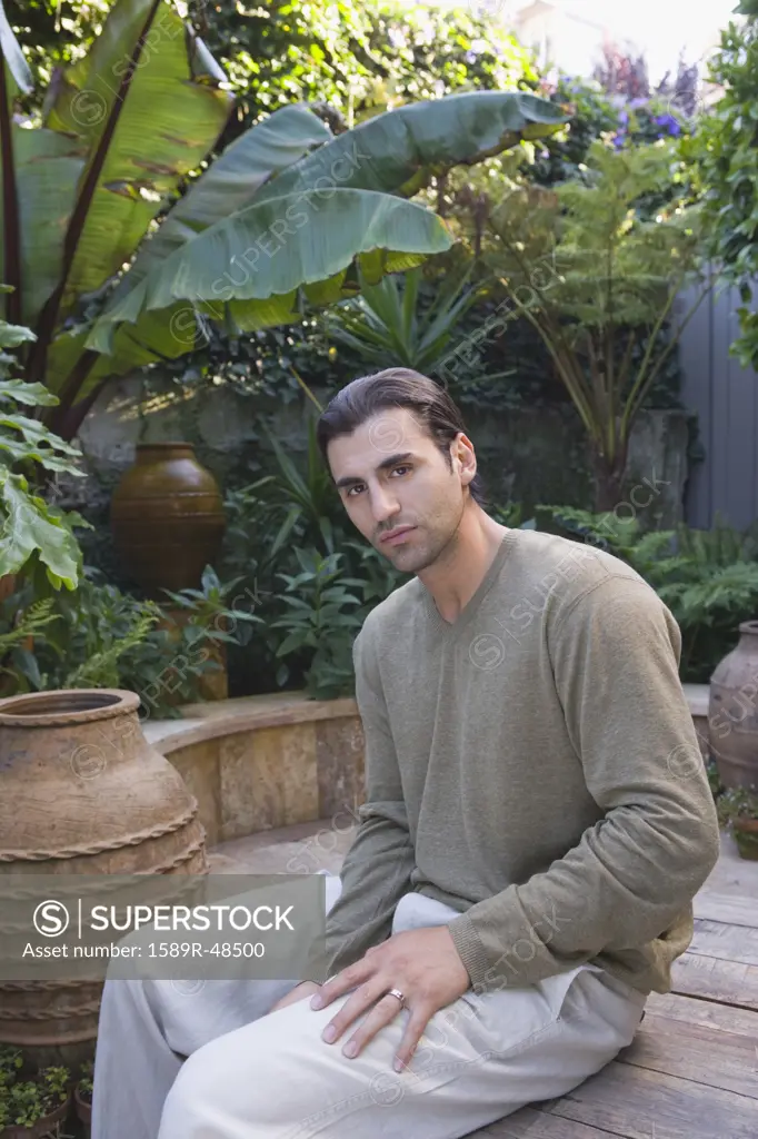 Hispanic man sitting in garden