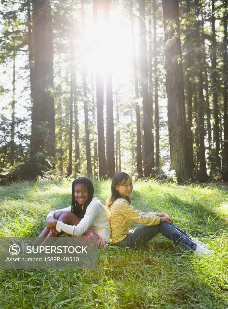 Multi-ethnic girls sitting in woods