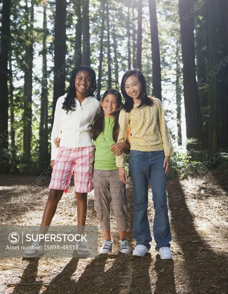 Multi-ethnic girls standing in woods
