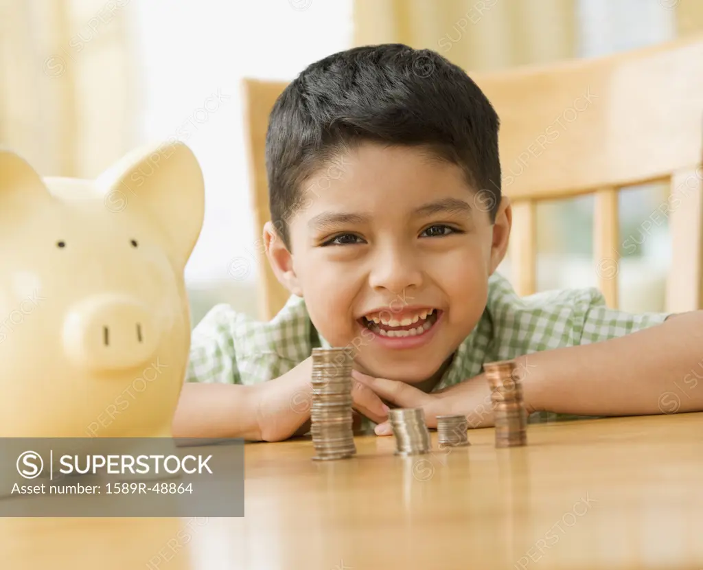 Mixed Race boy with stacks of coins