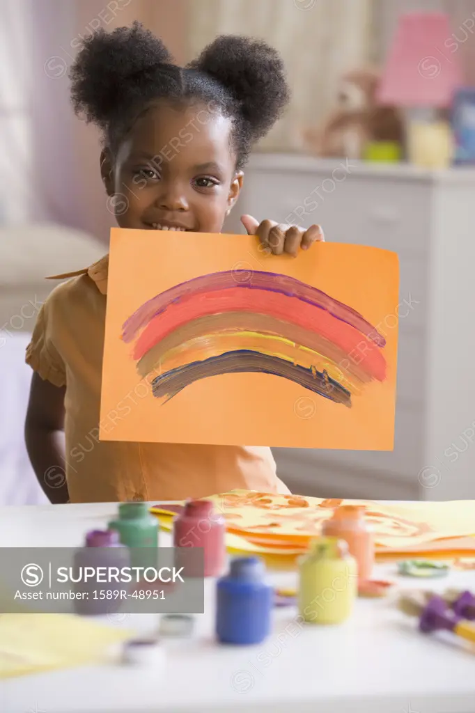 African American girl holding up painting