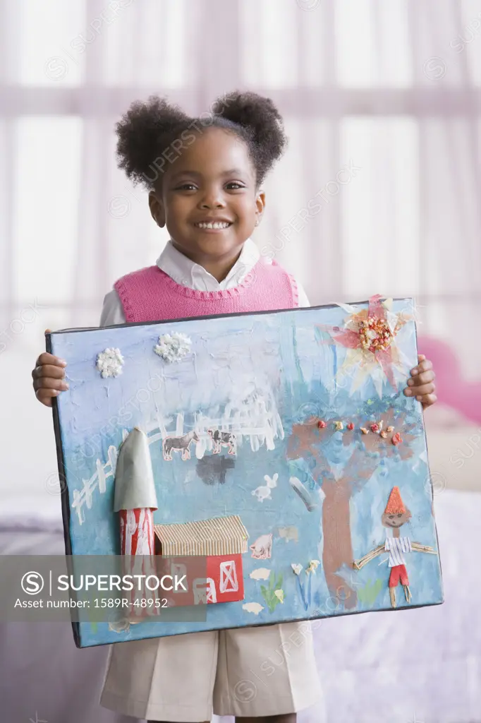 African American girl holding up art project