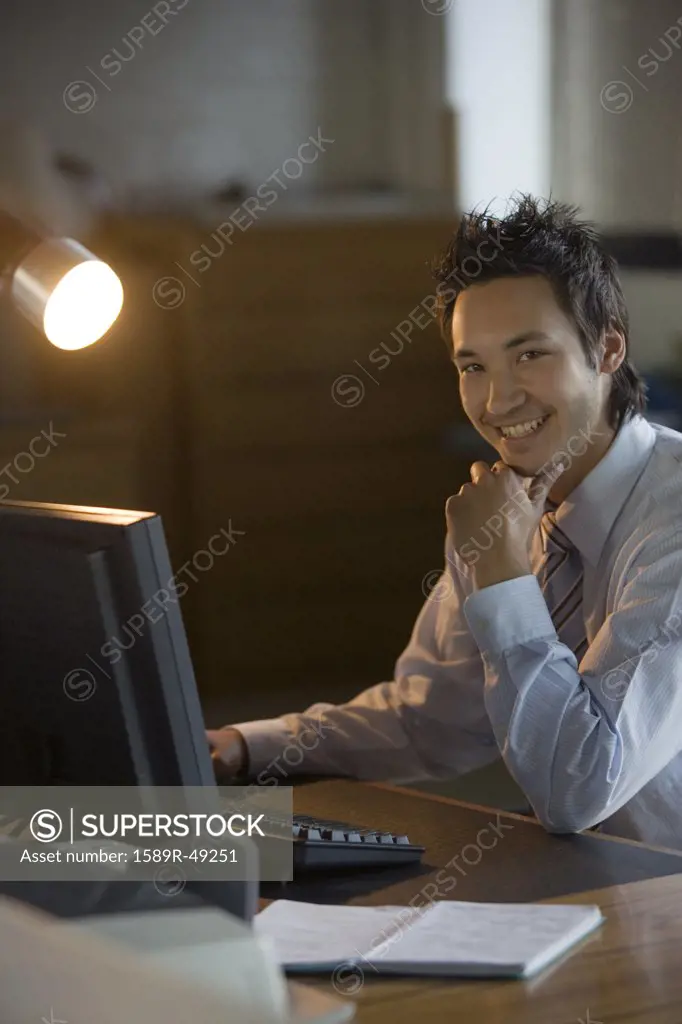 Asian businessman sitting at computer