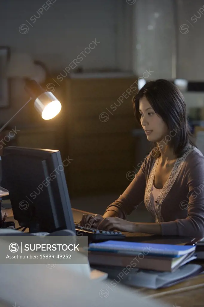 Asian businesswoman typing on computer