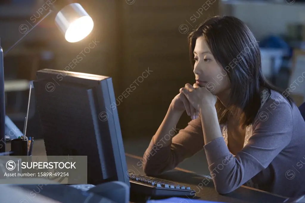 Asian businesswoman looking at computer