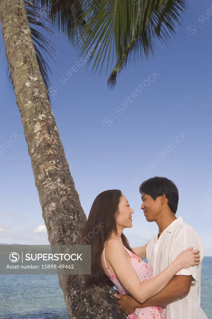 Asian couple hugging at beach
