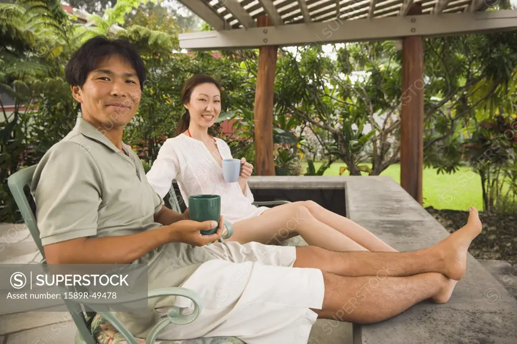 Asian couple on patio with coffee